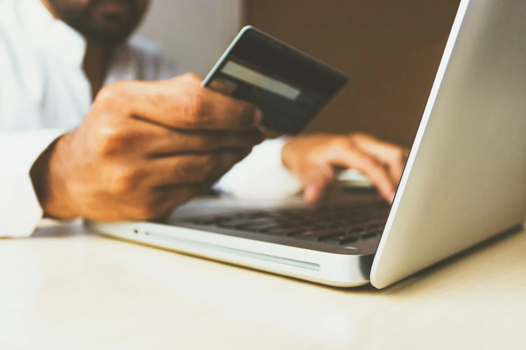 A shopper paying online with a credit card and laptop