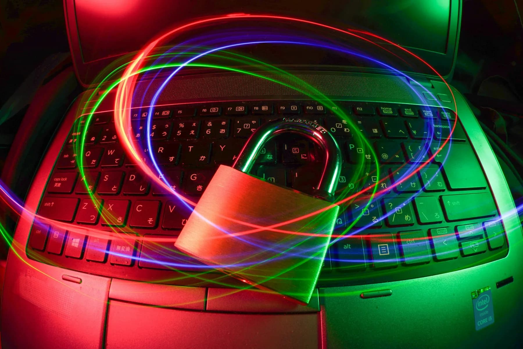 A padlock on a laptop keyboard surrounded by light trails
